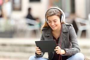 High school student watching movie on tablet for online classes